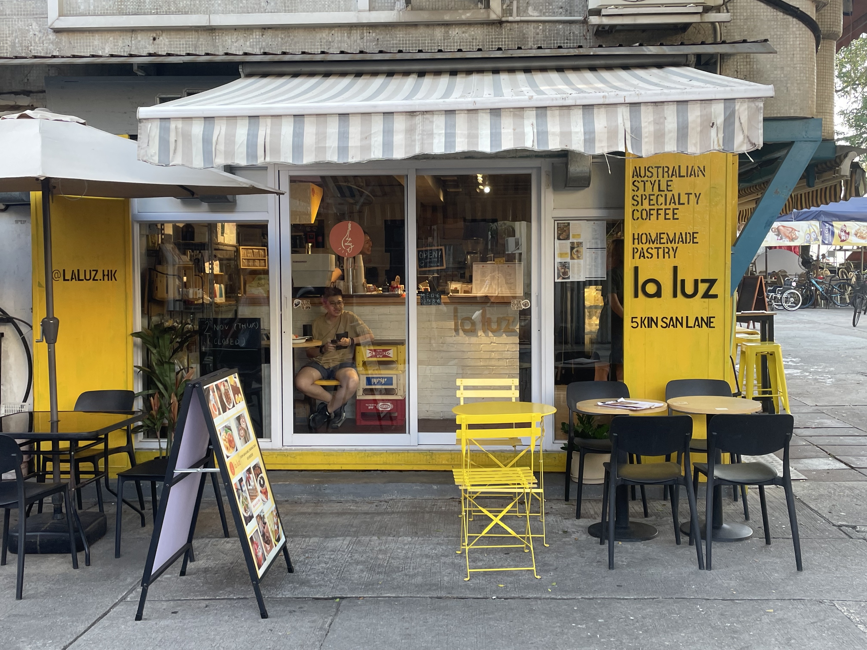 La Luz’s yellow storefront and outdoor tables at 5 Kin San Lane, Cheung Chau.