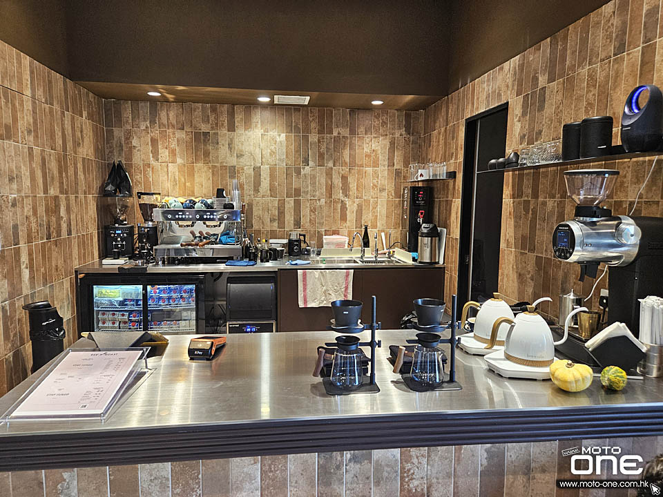 Rev N Roast’s coffee counter in Chai Wan, with brown tiled walls, espresso machine, grinders and pour-over equipment.