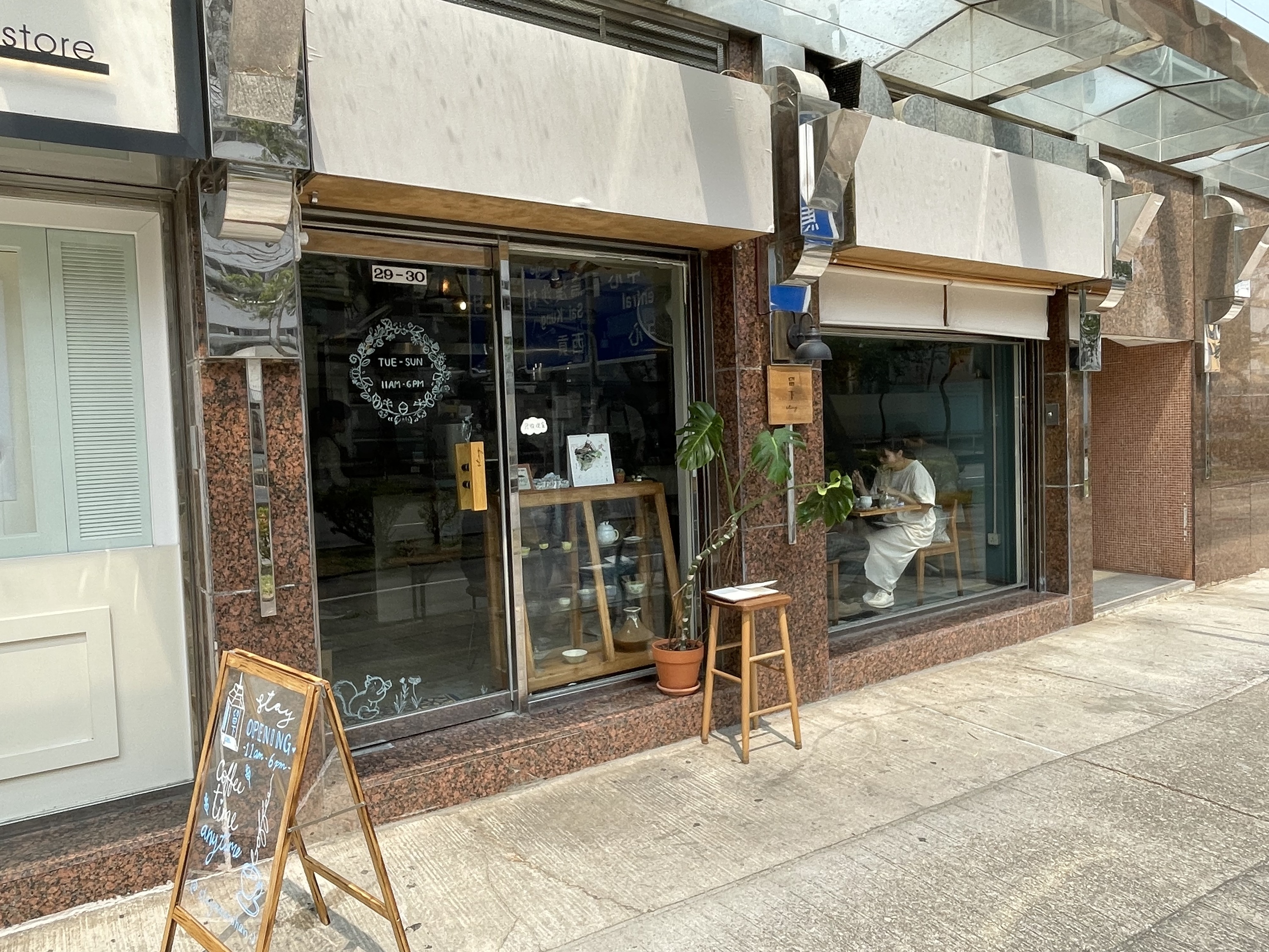 Stay café in Ma On Shan, with shop numbers 29–30 over the glass entrance and wooden furniture beside the window.