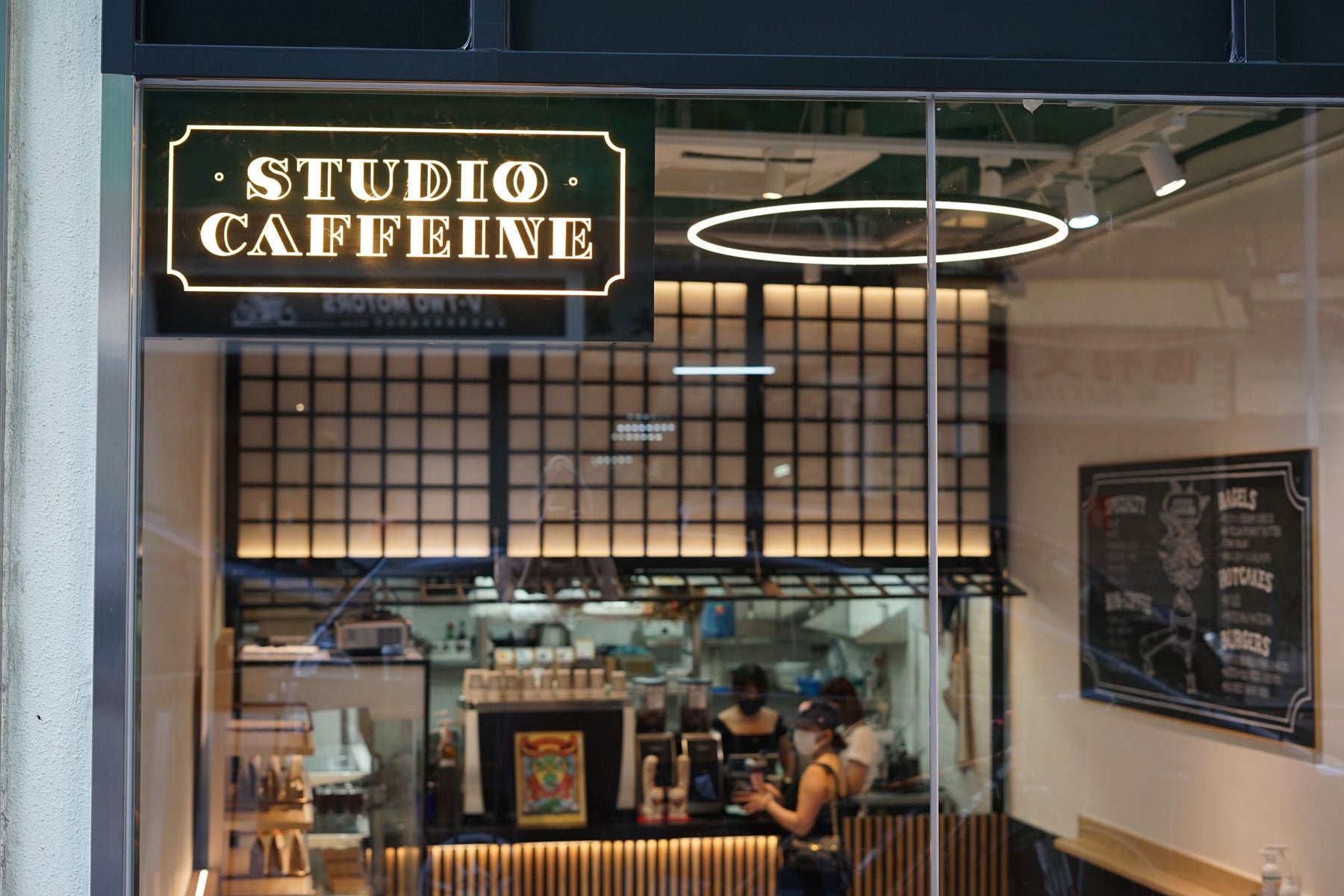 Studio Caffeine’s illuminated sign and coffee counter inside its Fo Tan shop.