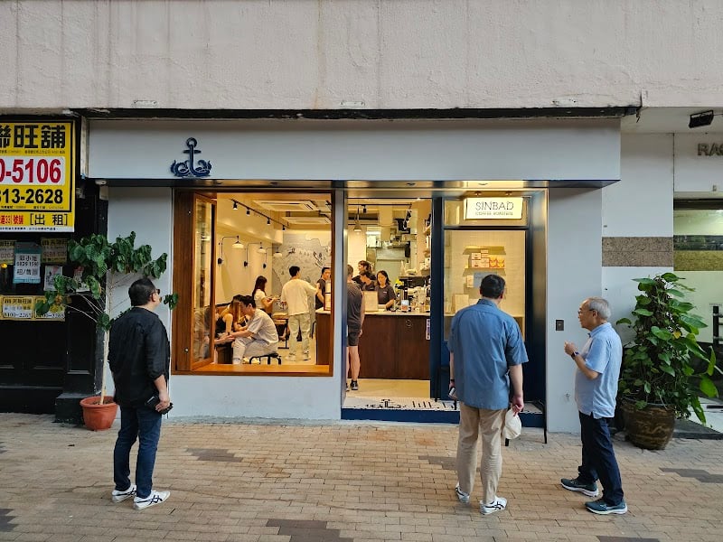 Sinbad Coffee Roasters’ blue-and-white storefront and seating at 31 Wong Nai Chung Road.