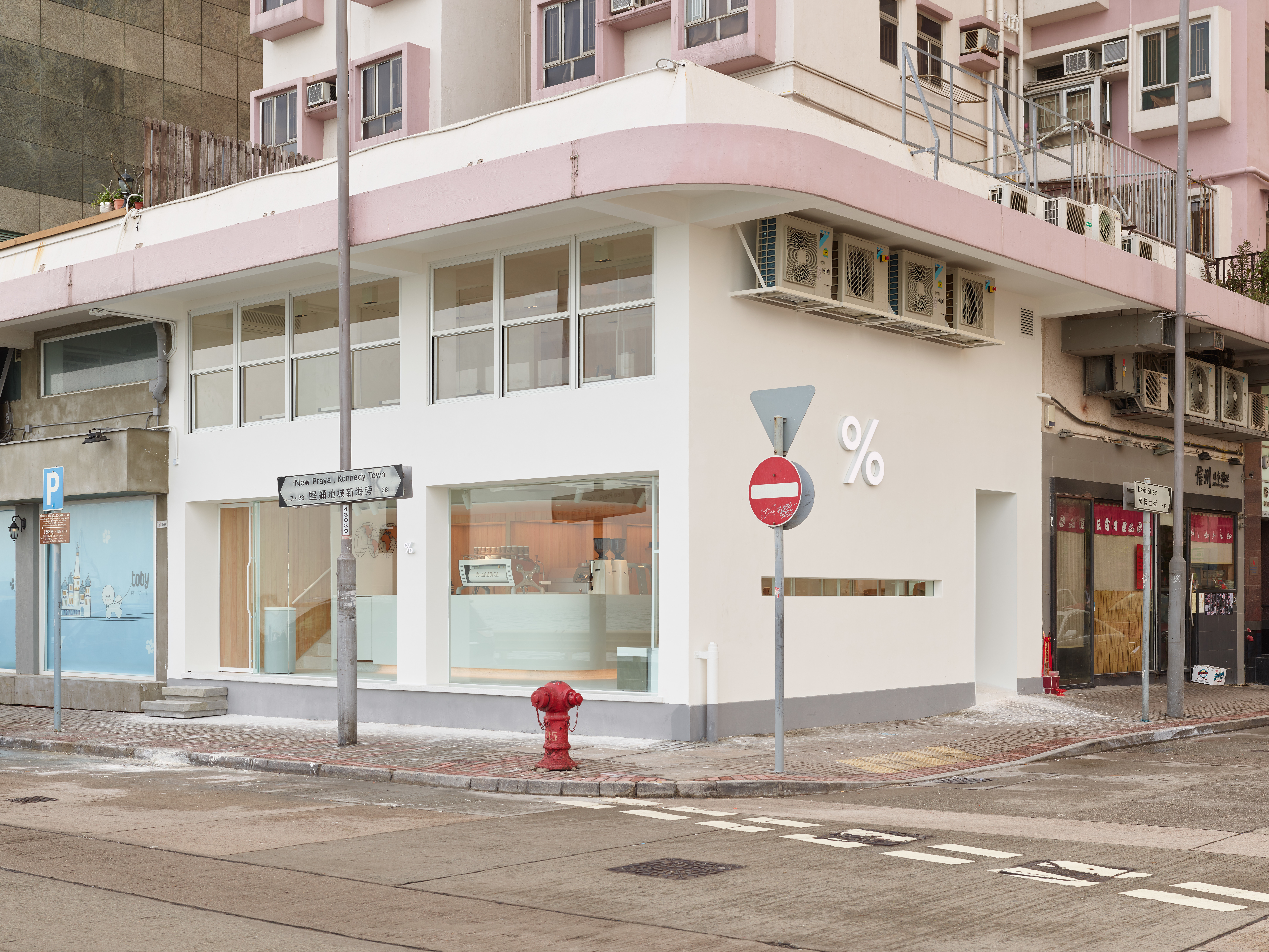 White two-storey % Arabica café at the corner of Davis Street and New Praya in Kennedy Town.