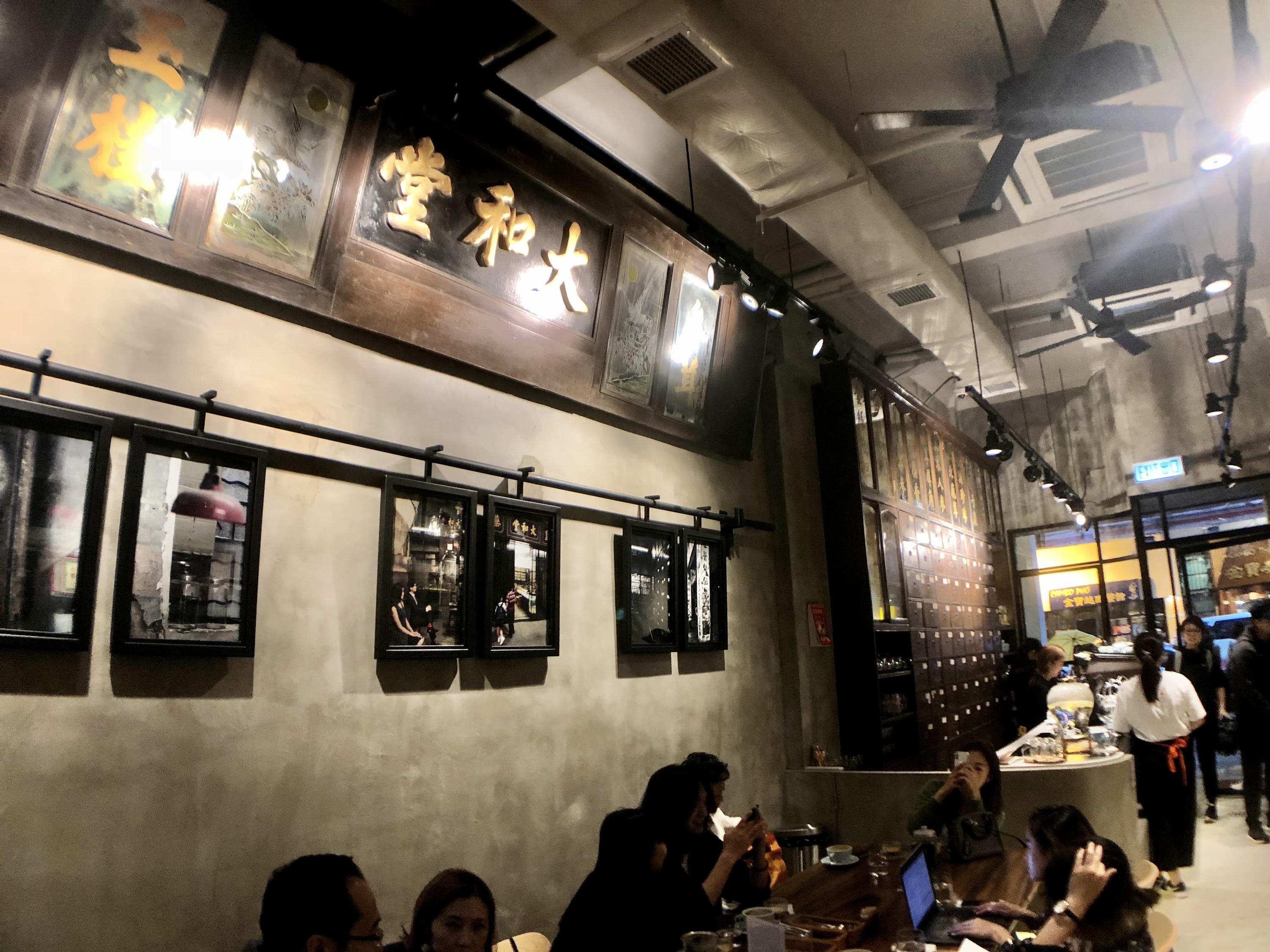 Historic gold signage and medicine drawers inside Tai Wo Tang café