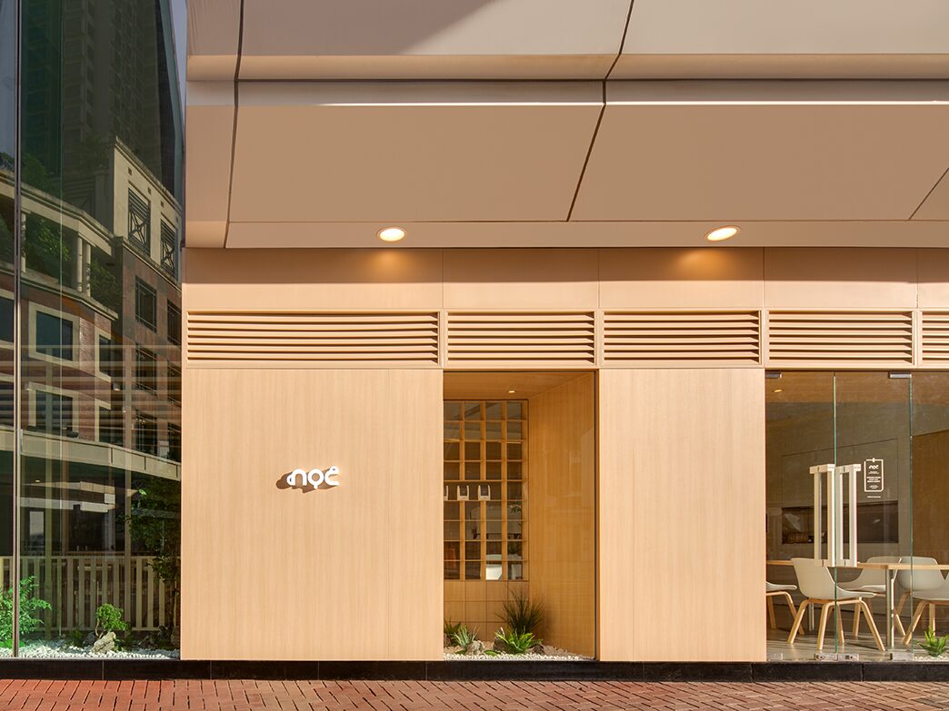 NOC Tsuen Wan Plaza wood-paneled storefront with pale chairs behind full-height windows