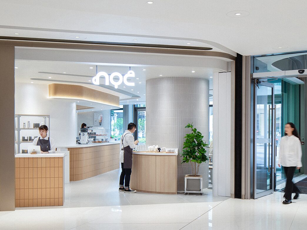 NOC at The Southside with curved wood counters and baristas beneath the illuminated cafe sign