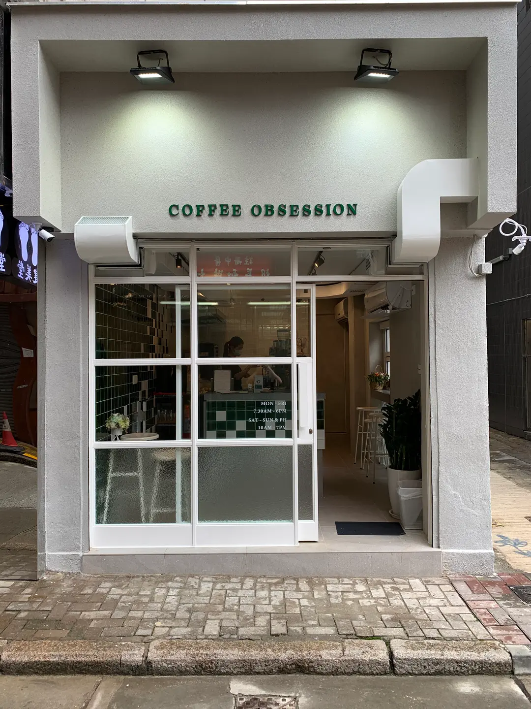 Coffee Obsession’s white storefront, green lettering and tiled counter on Boat Street.
