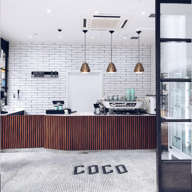 Coco Espresso’s Quarry Bay coffee counter with white subway tiles and COCO floor lettering.