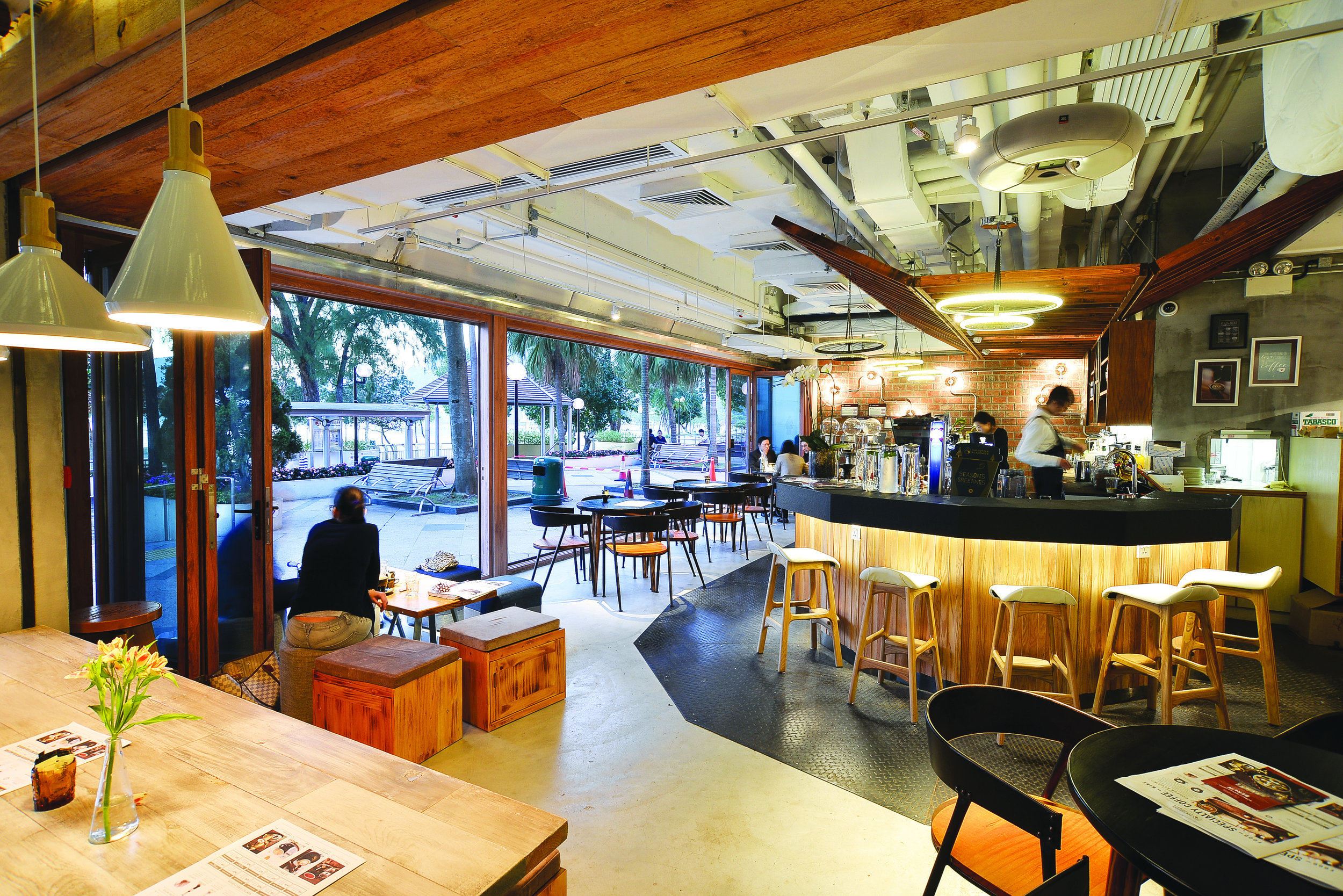 The Coffee Academïcs’ wooden tables and curved coffee bar beside the Repulse Bay promenade.