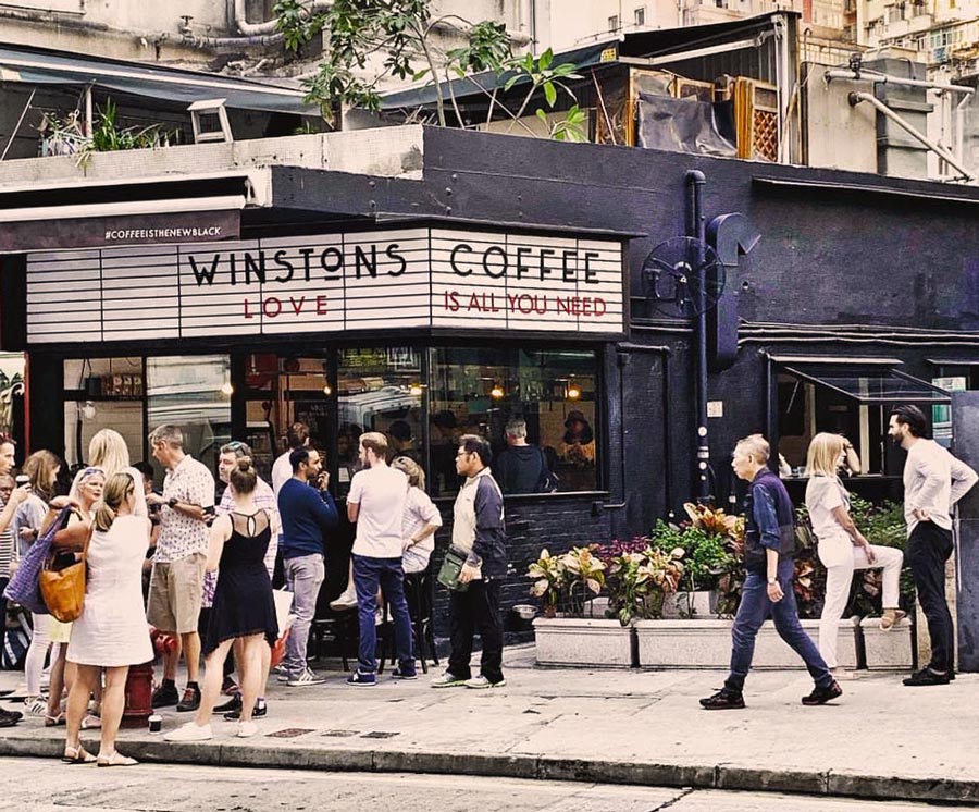 Customers outside Winstons in Sai Ying Pun beneath a black sign reading Love Is All You Need.