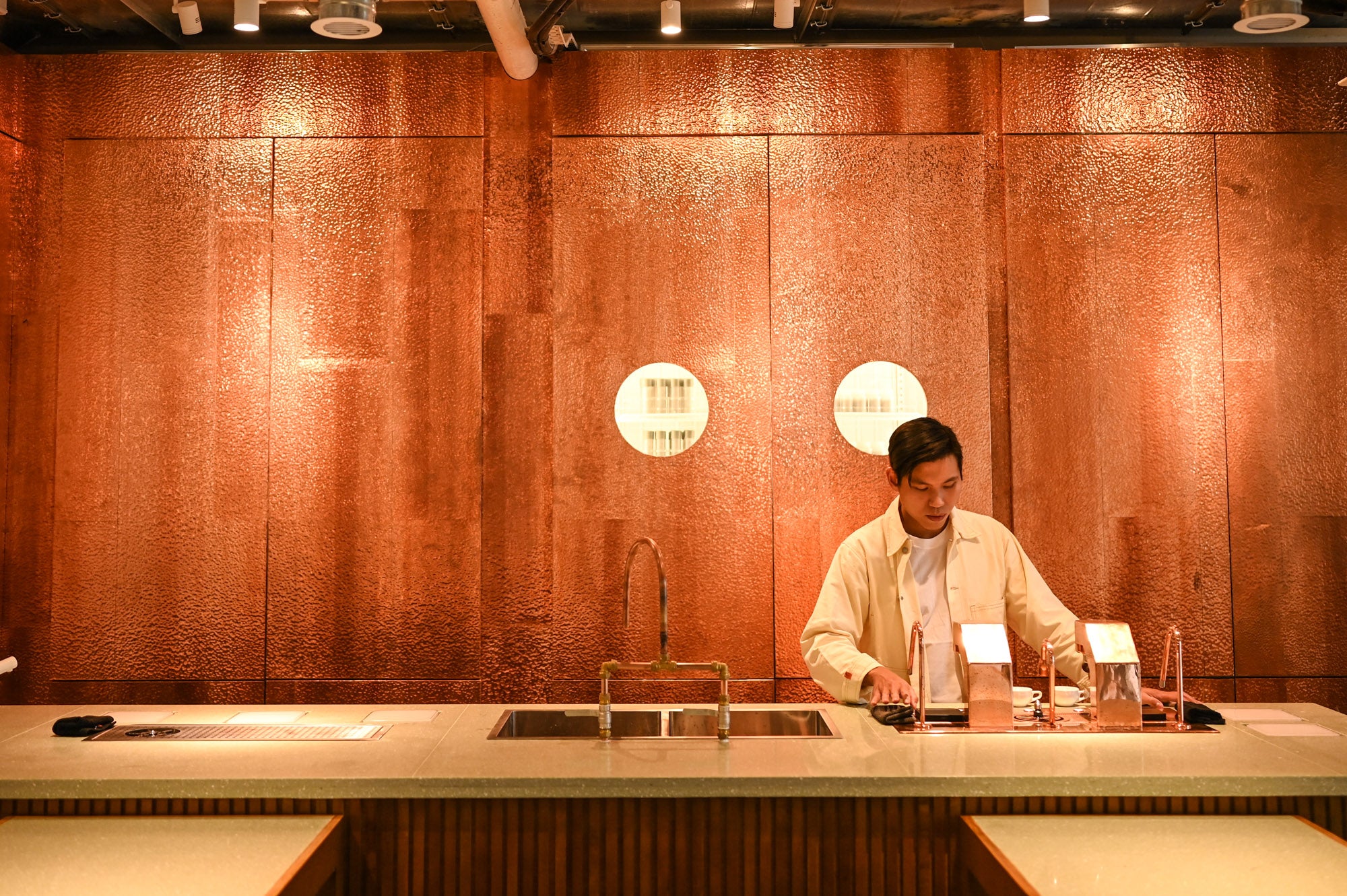 A barista behind the copper-toned brew bar at Urban Coffee Roaster in Tseung Kwan O.