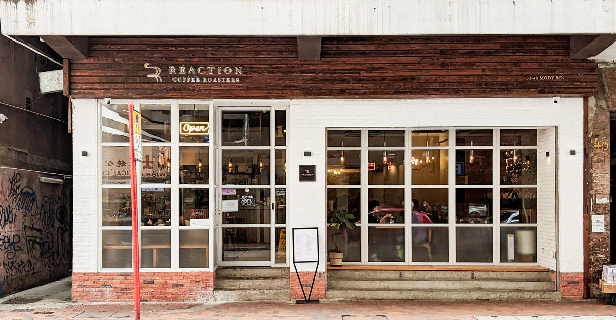 White brick shopfront of REACTION Coffee Roasters on Mody Road