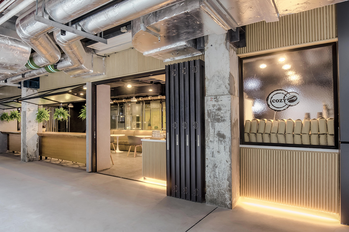 Cozy Coffee Club at The Mills, with warm timber counters and exposed industrial ceilings.