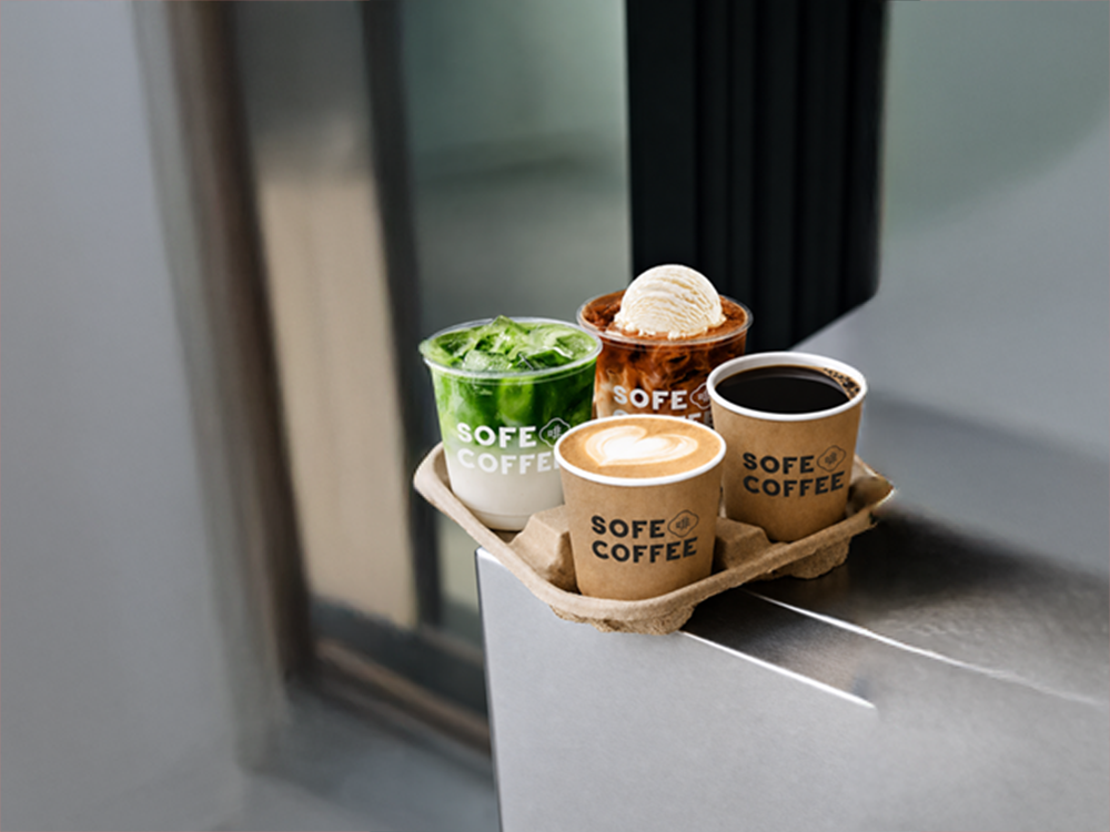 Four SOFE coffees and matcha drinks on a metal counter, pictured on the official WKCDA Tower cafe listing.